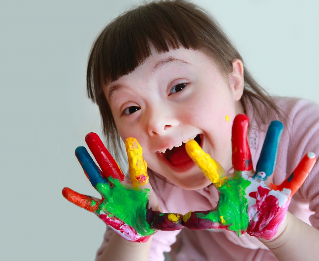 Cute little girl with painted hands. Isolated on grey background.